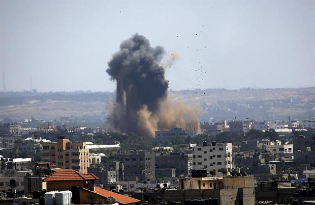 Una columna de humo se desprende de un edificio atacado en Gaza hoy, martes 15 de julio del 2014. La Fuerza Aérea israelí ha reanudado los ataques en Gaza en respuesta al disparo de decenas de cohetes por milicianos palestinos, a pesar de que el primer ministro, Benjamín Netanyahu, aceptó esta mañana un alto el fuego propuesto por Egipto. EFE/Mohammed Saber