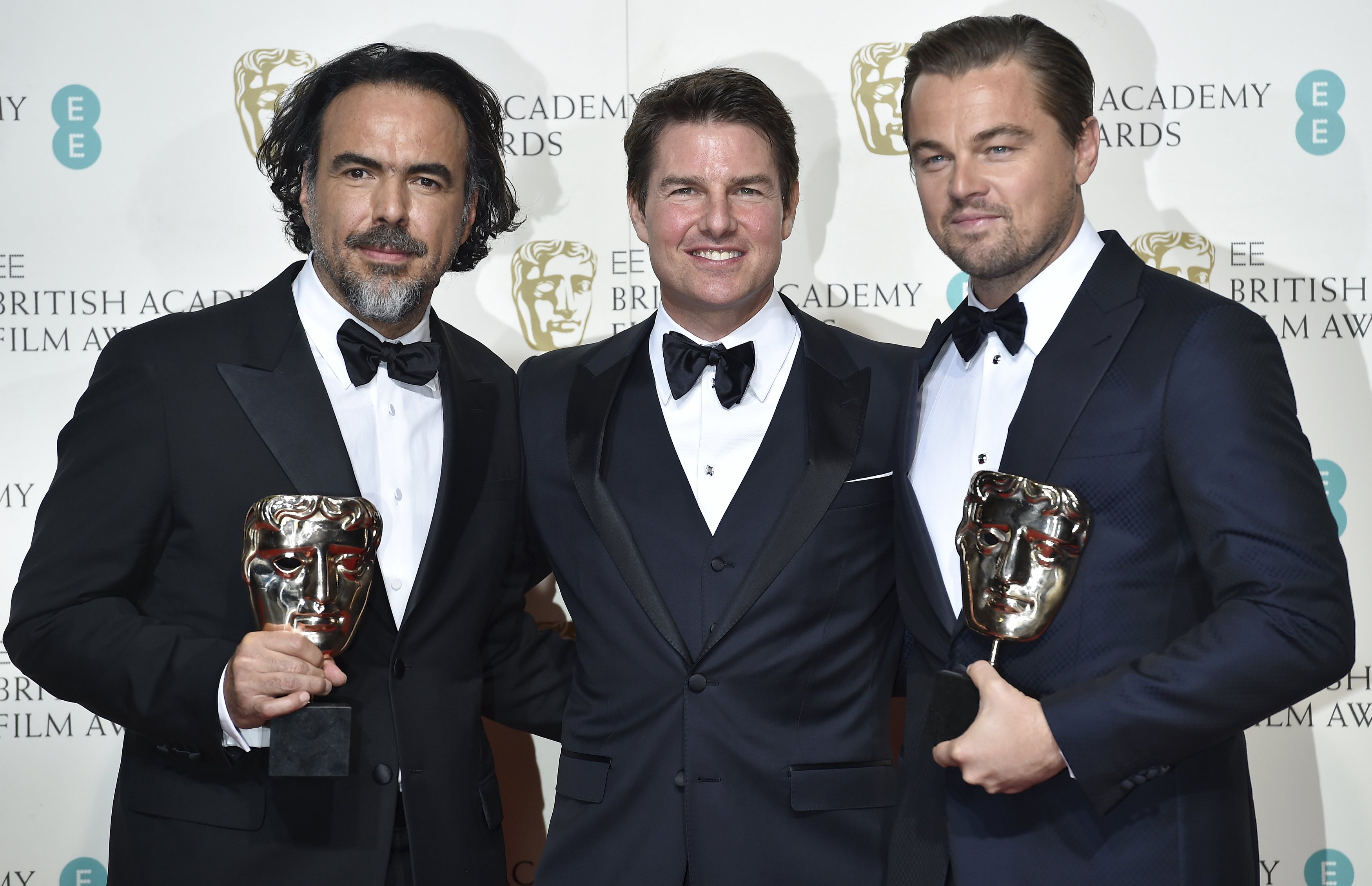 Best director Alejandro Inarritu (L) and best leading actor Leonardo DiCaprio hold their awards as they stand with presenter Tom Cruise at the British Academy of Film and Television Arts (BAFTA) Awards at the Royal Opera House in London, February 14, 2016. REUTERS/Toby Melville