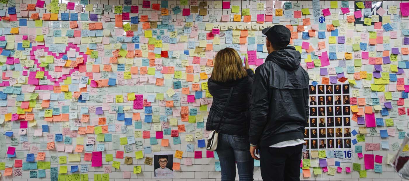 AVX8 NUEVA YORK (ESTADOS UNIDOS) 13/11/2016.- Dos ciudadanos observan las notitas de colores que cubren un muro y que forman parte de la pieza artística "Subway Therapy" en la estación de metro de Union Square en Manhattan, Nueva York (Estados Unidos) hoy, 13 de noviembre de 2016. El número de post-it de la obra, que inició el artista estadounidense Matthew Chavez el 10 de noviembre, continúa creciendo mientras los ciudadanos siguen añadiendo nuevas notas. EFE/Alba Vigaray