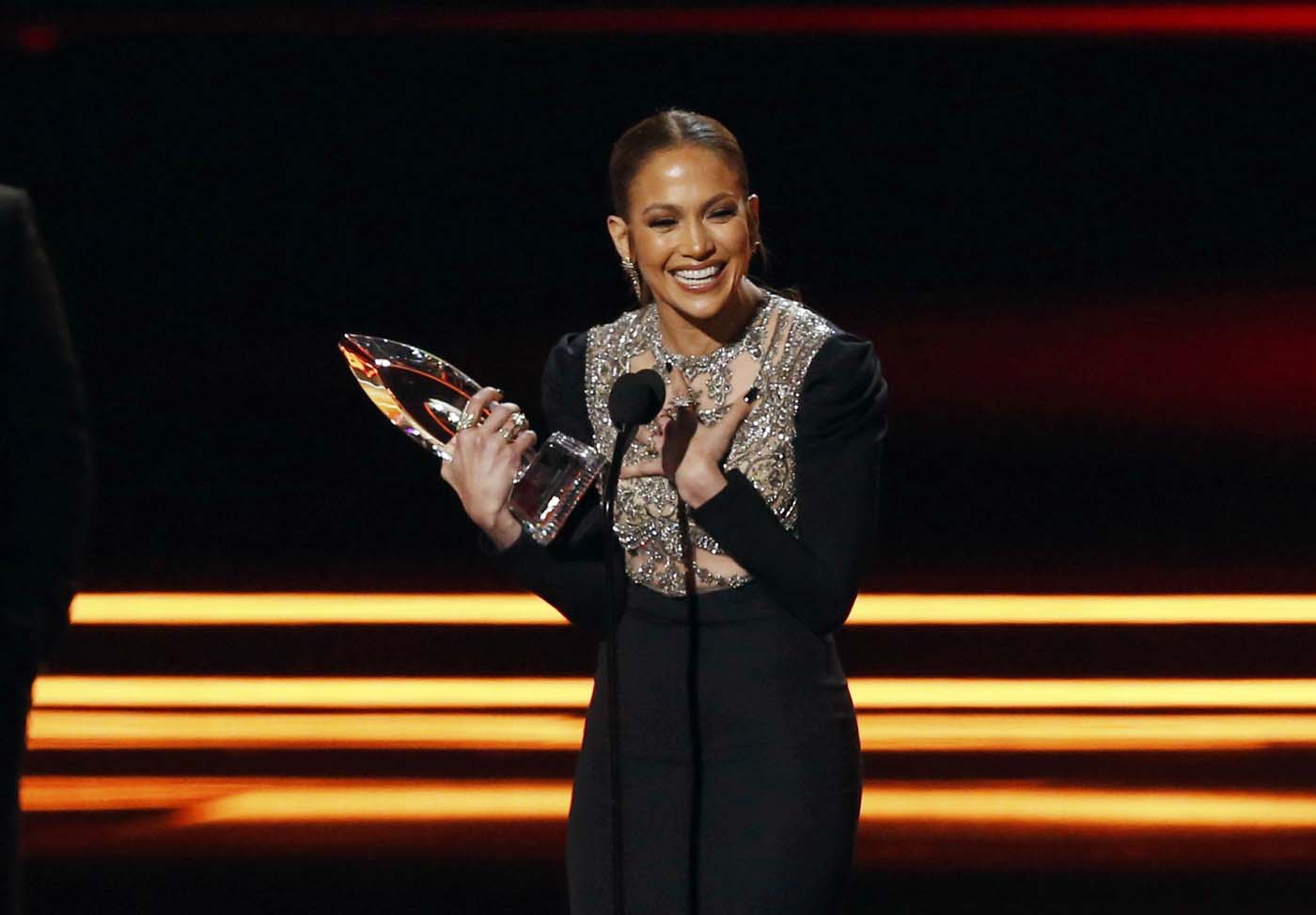 Actress Jennifer Lopez accepts the award for Favorite TV Crime Drama Actress as actors Dax Shepard (L) and Michael Pena look on during the People's Choice Awards 2017 in Los Angeles, California, U.S., January 18, 2017.   REUTERS/Mario Anzuoni