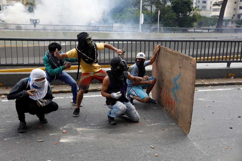 Demonstrators prepare to throw rocks as they clash with riot police during a rally in Caracas, Venezuela, April 8, 2017. REUTERS/Carlos Garcia Rawlins