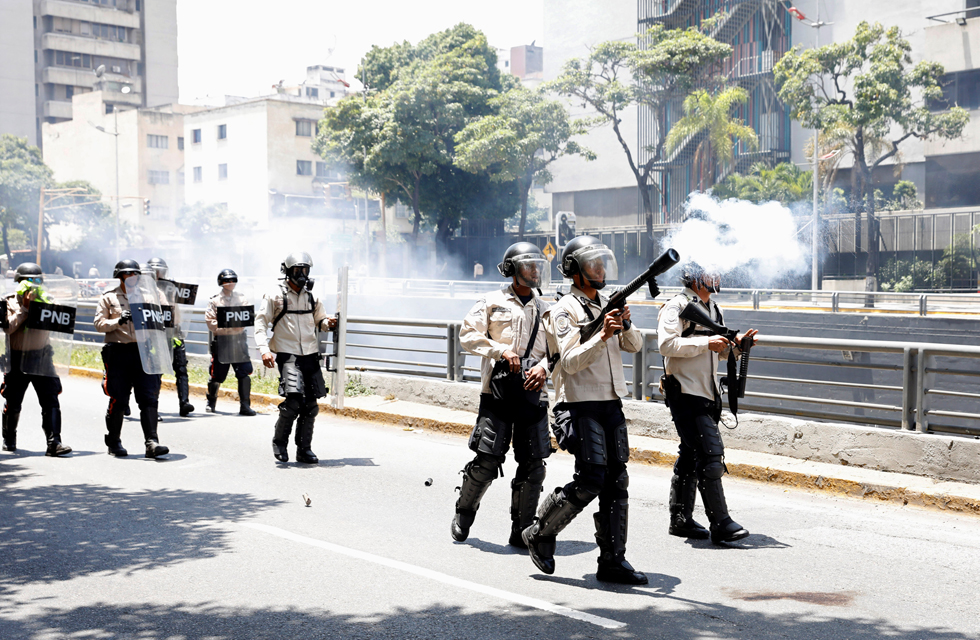 REFILE - CLARIFYING CAPTION Riot police offcer fires a tear gas canister during an opposition rally in Caracas, Venezuela, April 8, 2017. REUTERS/Carlos Garcia Rawlins