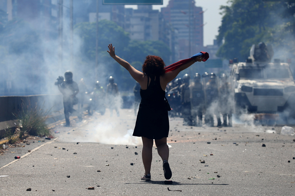 A demonstrator gestures in front of riot police during a rally in Caracas, Venezuela, April 8, 2017. REUTERS/Carlos Garcia Rawlins