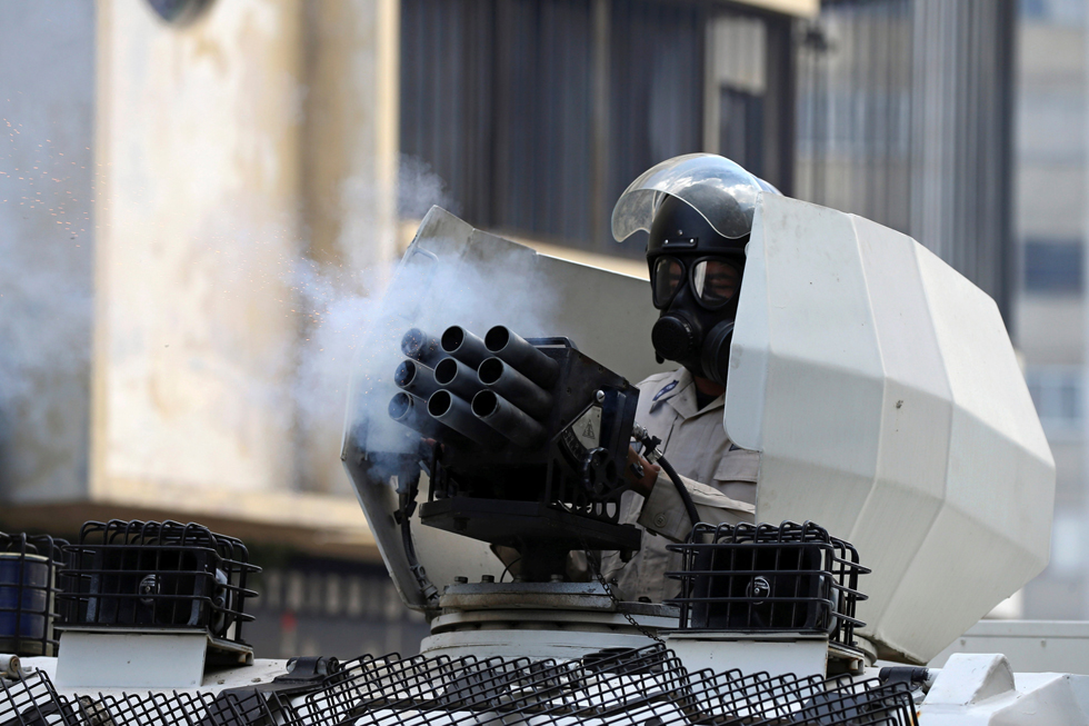 A riot police officer fires tear gas while clashing with demonstrators during a rally in Caracas, Venezuela, April 8, 2017. REUTERS/Carlos Garcia Rawlins