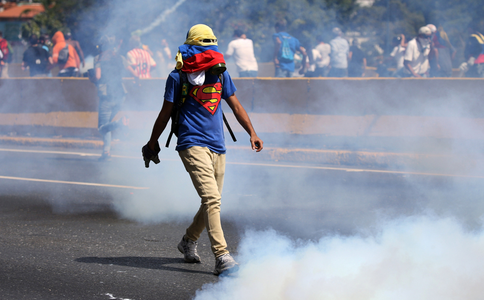 A demonstrator walks during clashes with riot police during a rally in Caracas, Venezuela, April 8, 2017. REUTERS/Carlos Garcia Rawlins