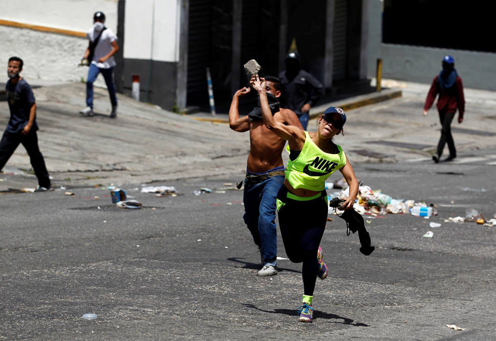 Demonstrators react during clashes with the riot police during a rally in Caracas, Venezuela, April 8, 2017. REUTERS/Christian Veron