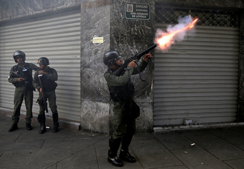 A riot police officer fires tear gas while clashing with demonstrators during a rally in Caracas, Venezuela, April 8, 2017. REUTERS/Marco Bello TPX IMAGES OF THE DAY