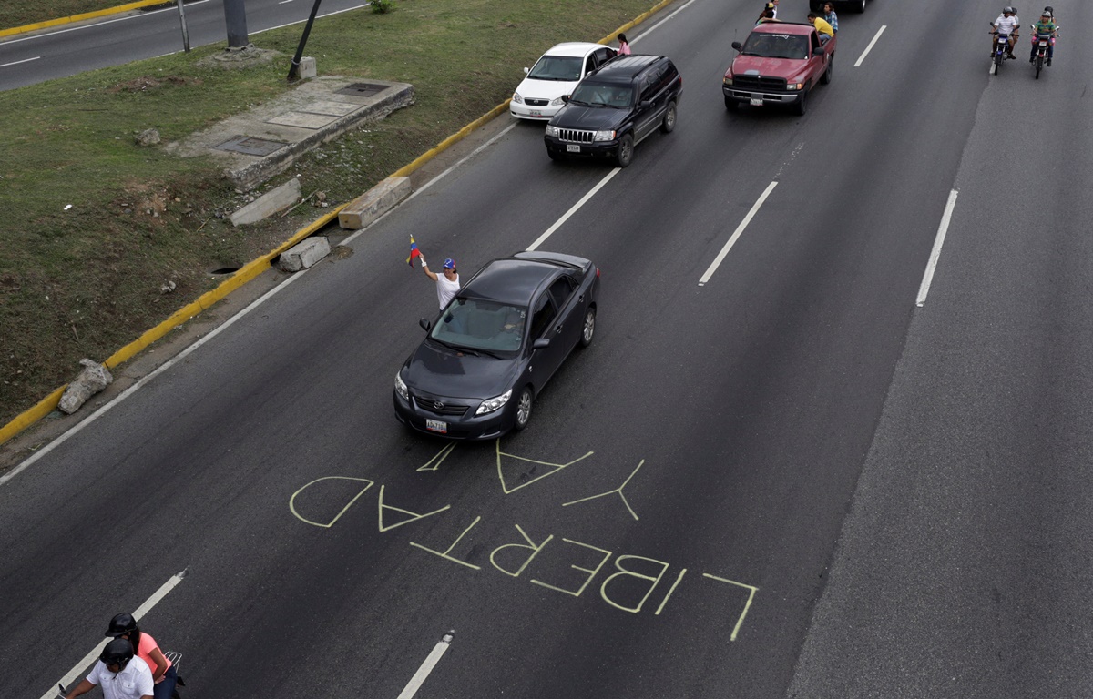 Demonstrators riding motorcycles and driving cars past a sign reading: 'Freedom now' take part in a nationwide protest against President Nicolas Maduro government, in Caracas, Venezuela, May 13, 2017. REUTERS/Marco Bello