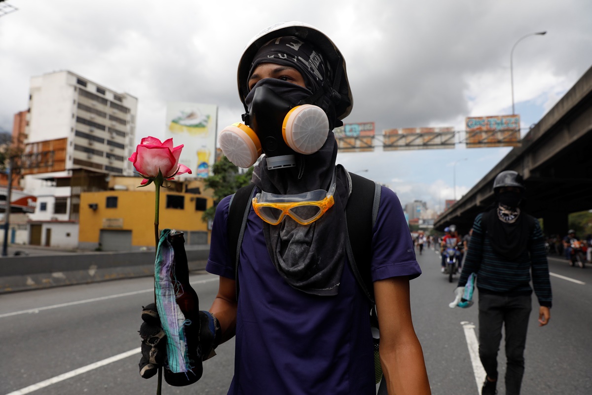 A demonstrator holds a flower during a protest against Venezuela's President Nicolas Maduro's government in Caracas, Venezuela, May 13, 2017. REUTERS/Carlos Garcia Rawlins