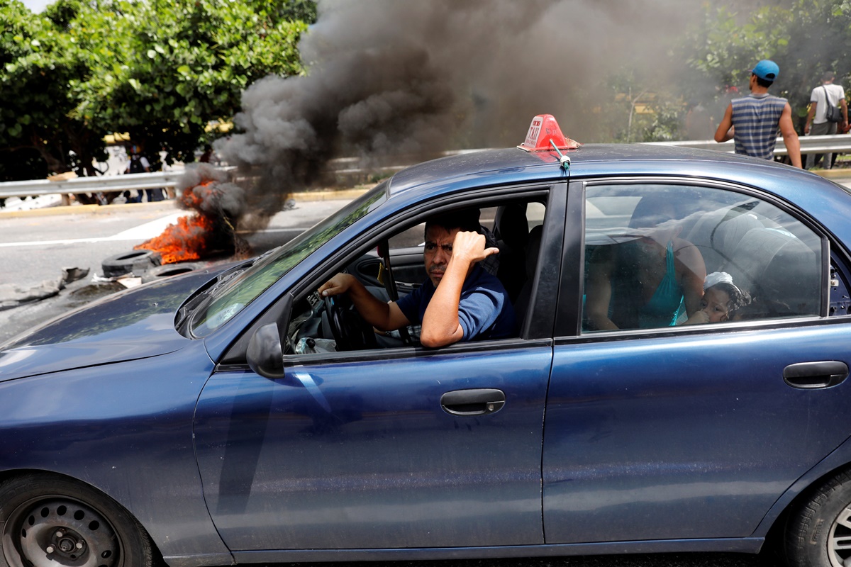 A driver pasts near barricade during a protest against Venezuela's President Nicolas Maduro's government in Caracas, Venezuela, May 13, 2017. REUTERS/Carlos Garcia Rawlins