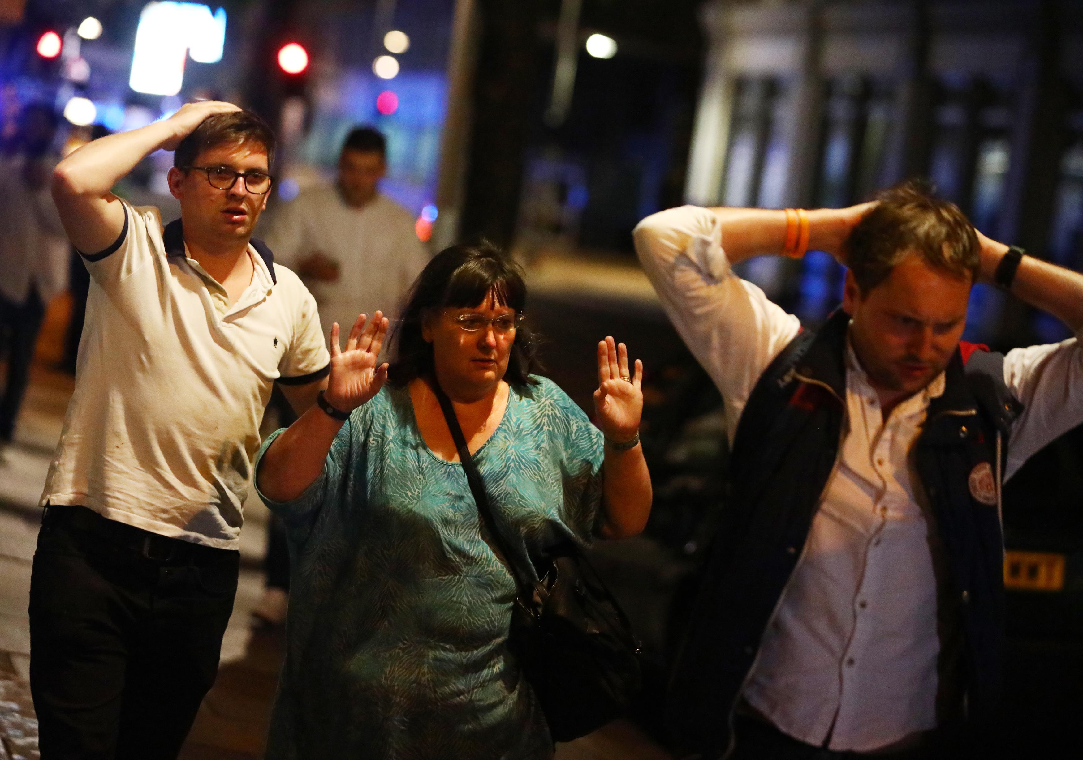 People leave the area with their hands up after an incident near London Bridge in London, Britain June 4, 2017. REUTERS/Neil Hall