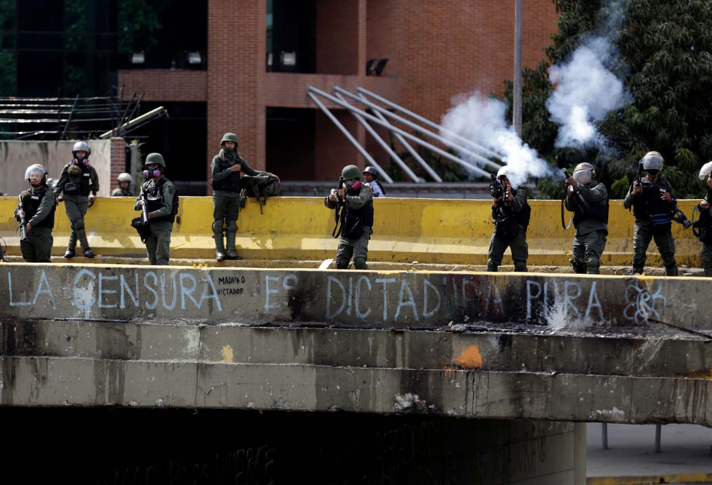 Security forces fire tear gas during clashes at a rally against Venezuelan President Nicolas Maduro's government in Caracas, Venezuela, July 6, 2017. The grafitti below them reads "Censorship is pure dictatorship". REUTERS/Marco Bello
