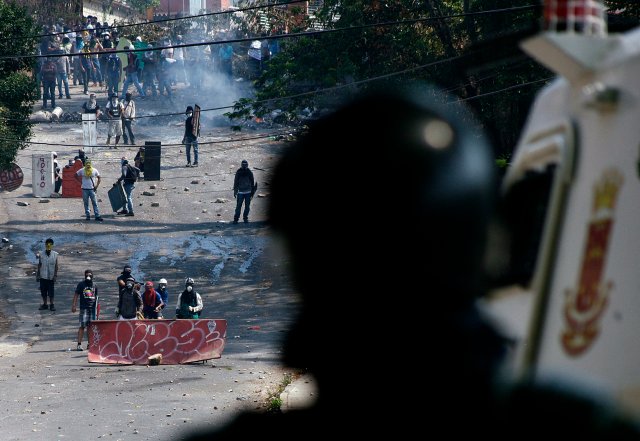 Anti-government protesters clash with a member of the National Guard during a protest in San Cristobal