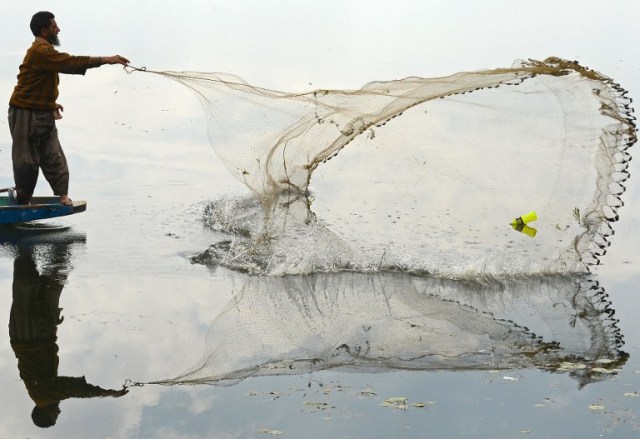 Un pescador lanza una red de Cachemira en las aguas del lago Dal durante una huelga de un día convocada por el líder separatista de línea dura, Syed Ali Shah Geelani en Srinagar / Mustafa Tauseef / AFP