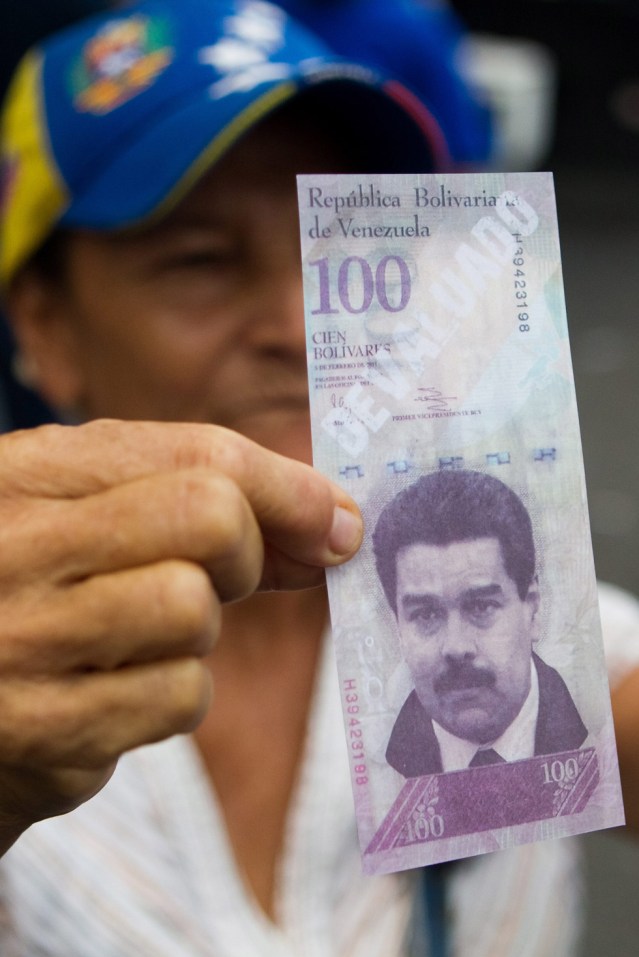 Foto: Una mujer muestra un billete falso con la imagen del presidente de Venezuela Nicolás Maduro y la palabra "devaluado" hoy, lunes 12 de mayo de 2014, durante una manifestación en contra del gobierno venezolano en Caracas (Venezuela). EFE/MIGUEL GUTIÉRREZ