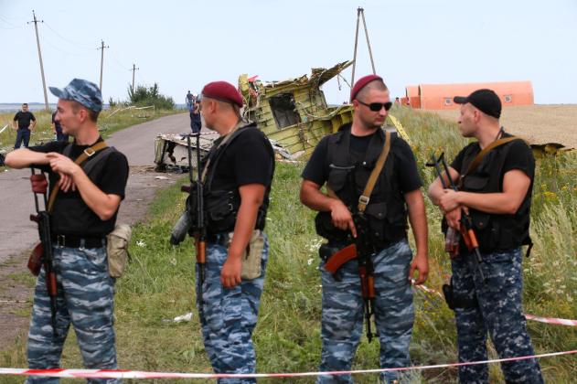 Armed pro-Russian separatists stand guard at a crash site of Malaysia Airlines Flight MH17, near the village of Hrabove