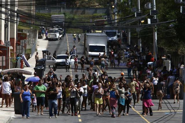 Familias dejan una urbanización, construida por el Gobierno brasileño y ocupada ilegalmente, durante un desalojo realizado hoy, miércoles 19 de noviembre de 2014, en Río de Janeiro (Brasil). Aproximadamente 200 familias se retiraron de esta urbanización de apartamentos populares que fue ocupada ilegalmente desde principios del mes de noviembre. EFE/Marcelo Sayão