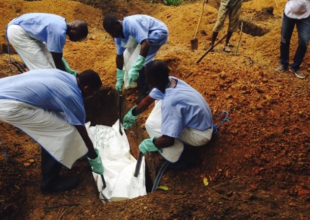 Foto; Un grupo de voluntarios desciende un cuerpo, preparado con medidas funerarias seguras, a una tumba en Kailahun, Sierra Leona / Reuters