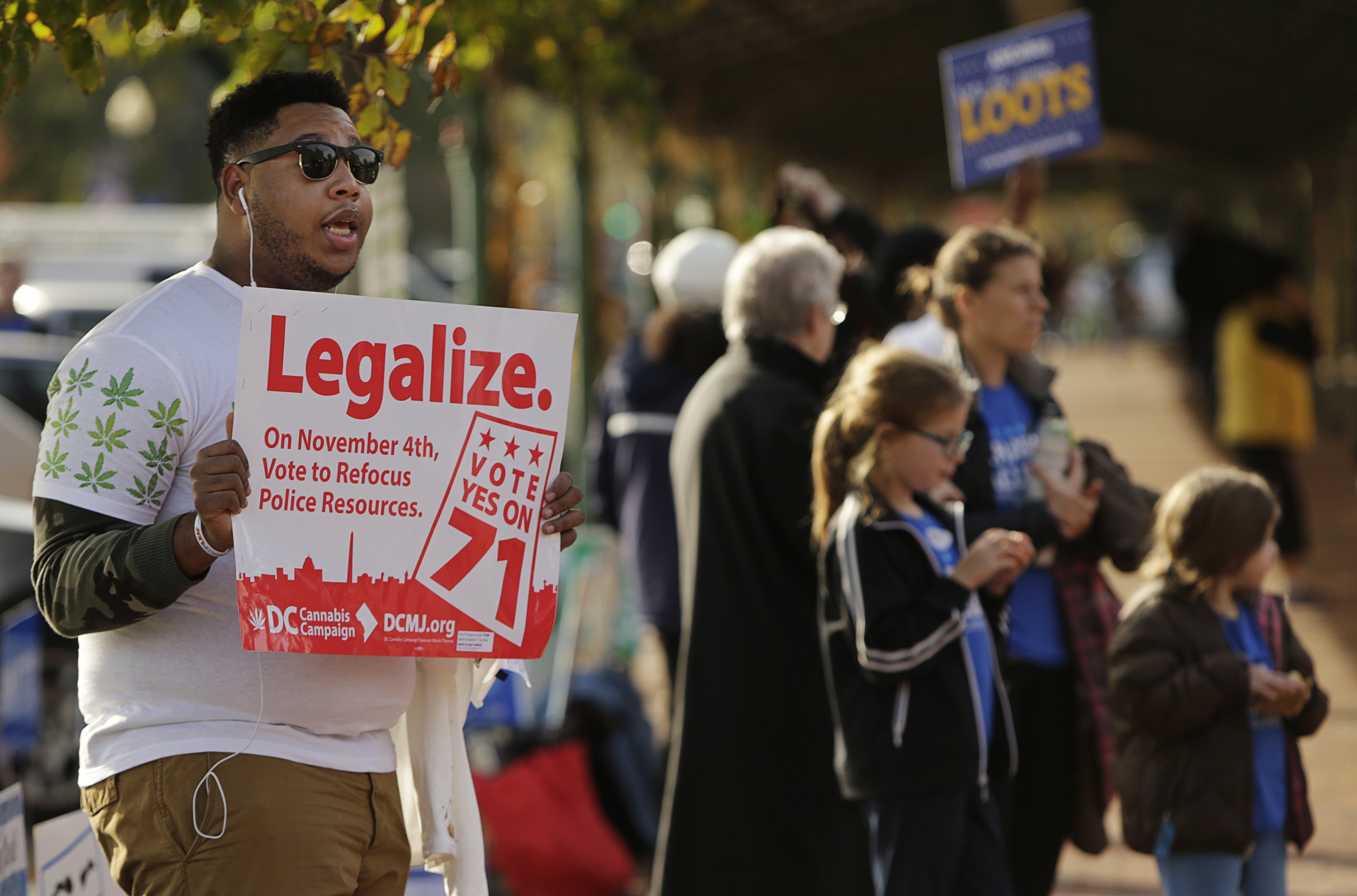 Melvin Clay of the DC Cannabis Campaign holds a sign urging voters to ...