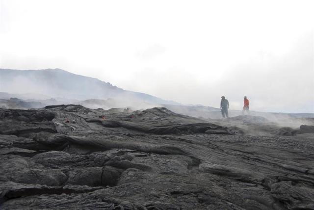 Fotografía aérea tomada el 16 de diciembre de 2014 y facilitada por el Servicio Geológico de Estados Unidos (USGS) hoy, miércoles 17 de diciembre de 2014, de un par de geólogos mientras caminan sobre el tubo de lava para su supervisión en Hawai (Estdos Unidos). El río de lava del volcán Kilauea en Hawai (EE.UU.) se dirige hacia el pueblo de 1.000 habitantes que mantuvo amenazado durante varias semanas, después de que a mediados de noviembre se estabilizara durante un tiempo. EFE/Fa Trusdell/USGS 