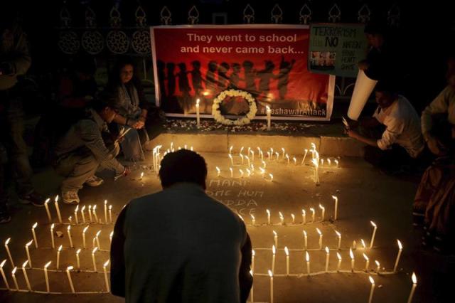 Una familia india enciende velas durante una ceremonia en memoria de las víctimas del ataque talibán perpetrado ayer en un colegio paquistaní en Bangalore, en la India, hoy, miércoles 17 de diciembre de 2014. En el cartel, al fondo, se lee "Se fueron al colegio y nunca regresaron". Pakistán entierra hoy a sus muertos en el asalto a una escuela, en el que fueron asesinados 132 estudiantes, en una jornada en la que el Gobierno levantó la moratoria sobre la pena de muerte en los casos de terrorismo y reafirmó su determinación en la guerra contra los talibanes. EFE/Piyal Adhikary