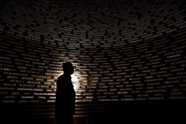 Un visitante observa los nombres de las víctimas en el Museo del tsunami de Aceh, en Banda Aceh (Indonesia), hoy, 25 de diciembre de 2014, víspera del décimo aniversario del devastador tsunami que se formó tras un fuerte terremoto en Indonesia y que mató a unas 230.000 personas en una docena de naciones bañadas por el océano Índico. EFE/Adi Weda