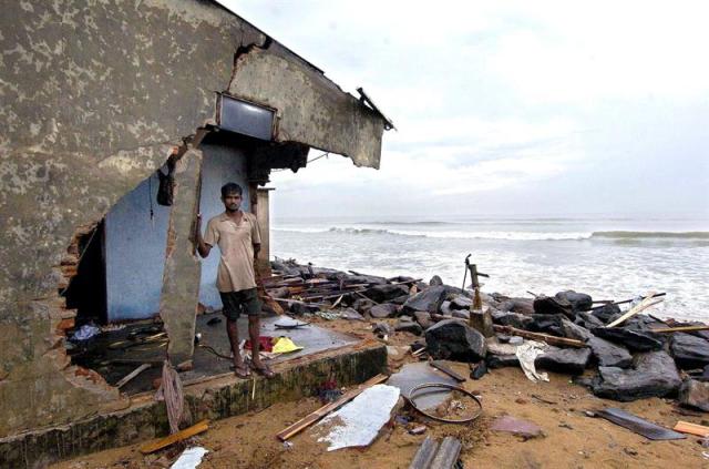 Foto de archivo tomada el 28 de diciembre de 2004 del carpintero Rengith Peris mientras permanece en su casa destrozada en Muratuwa, sur de Colombo (Sri Lanka). El 26 de diciembre de 2014 se cumple el décimo aniversario del tsunami que se formó tras un fuerte terremoto en Indonesia y que mató a unas 230.000 personas en una docena de naciones bañadas por el océano Índico. El tsunami golpeó las costas de Sri Lanka y de la India lo que causó la muerte de más de 35.000 y 12.000 personas, respectivamente. EFE/Peter Endig