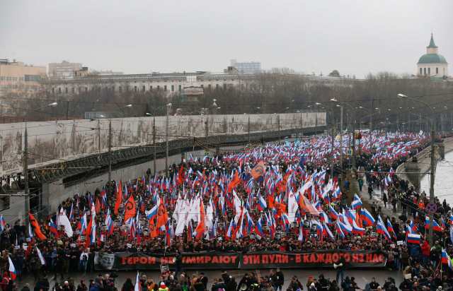 People march behind a large banner to commemorate Kremlin critic Boris Nemtsov, who was shot dead on Friday night, in central Moscow