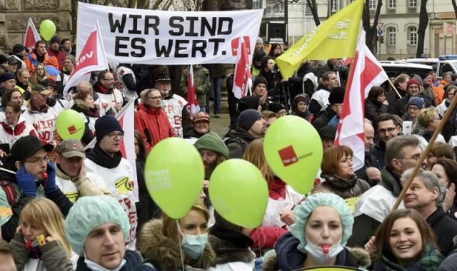 Empleados públicos protestan ante el Ministerio de Finanzas sosteniendo una pancarta en la que se puede leer "Nosotros lo valemos" mientras exigen una subida de sueldo en Hannover (Alemania) hoy, miércoles 4 de marzo de 2015. EFE/Holger Hollemann