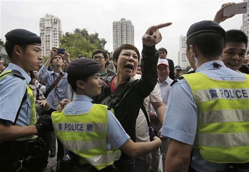 Una residente, centro, gesticula hacia manifestantes contra compradores de la China continental en Yuen Long, en Hong Kong, el 1 de marzo de 2015. (Foto AP/Vincent Yu)