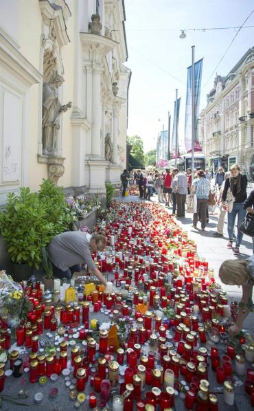 Varios ciudadanos dejan flores y velas en el lugar del suceso en memoria de las víctimas en Graz (Austria) hoy, lunes 22 de junio de 2015. Un conductor atropelló deliberadamente a decenas de personas en una zona peatonal de Graz el pasado 20 de junio lo que causó la muerte de al menos tres personas y varios heridos. EFE/Erwin Scheriau