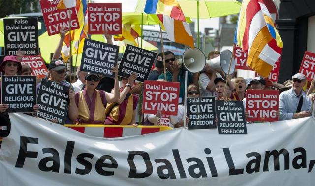 Varias personas se manifiestan contra el dalái lama, líder espiritual de los tibetanos, frente al centro budista que inauguró por su rechazo a los practicantes del buda de la sabiduría Doryhe Shugden en Aldershot, Reino Unido, hoy 29 de junio de 2015. EFE/Will Oliver