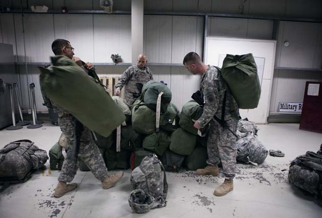 U.S. Army personnel retrieve their gear as they prepare to fly out of the former Sather Air Base in Baghdad