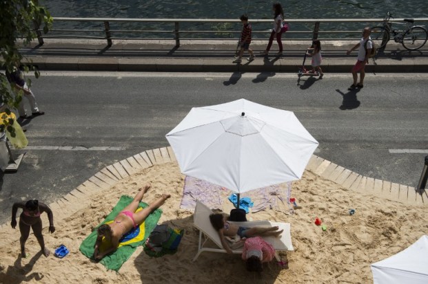 Foto: Personas tendidas en la arena de una playa artificial temporal establecido en las orillas del río Sena, como parte de la 14ª edición de Paris Plages el 21 de julio de 2015, en París. Paris Plages corre del 20 de julio al 23 de agosto de 2015 / AFP