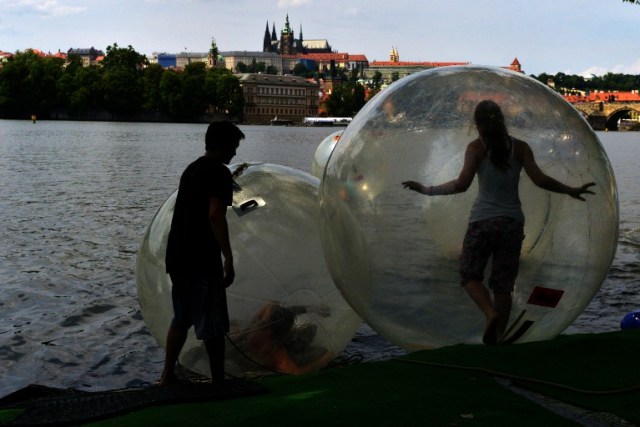 Tourists play in zorb balls on the Vltava river as temperatures reached 34 degrees Celsius on July 18, 2015 in Prague, Czech Republic.AFP PHOTO/MICHAL CIZEK