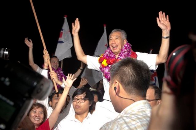 El primer ministro de Singapu, Lee Hsien Loong, festeja su triunfo electoral, sábado 12 de septiembre de 2015. El partido que ha gobernado Singapur durante medio siglo regresó al poder por cinco años más, después de ganar la mayoría en las elecciones generales. (AP Foto/Ng Han Guan)