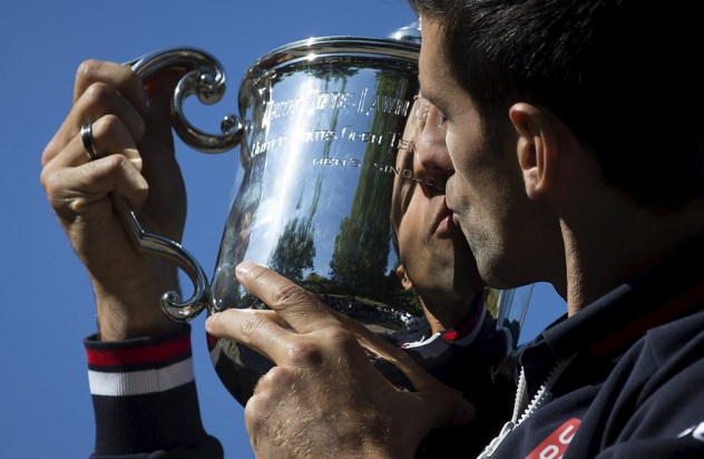 Novak Djokovic of Serbia kisses the champion's trophy as he poses for photos in Central Park a day after winning the U.S. Open Championships men's tennis tournament in New York, September 14, 2015. REUTERS/Carlo Allegri