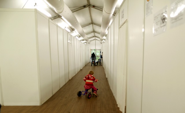 Una joven monta su bicicleta en una tienda de campaña en un refugio temporal para los migrantes en Düsseldorf, Alemania 15 de octubre de 2015. REUTERS / Ina Fassbender