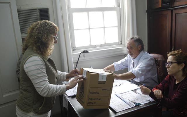 MON06. MONTEVIDEO (URUGUAY), 25/10/2015.- Una mujer deposita su voto hoy, domingo 25 de octubre de 2015, en el Consulado General de Argentina en Montevideo. Los argentinos residentes en las seis circunscripciones consulares de ese país en Uruguay acuden hoy a las urnas con motivo de las elecciones nacionales, la mayoría de ellos en el consulado de Montevideo, donde los comicios transcurren en "perfecta tranquilidad" dijo a Efe la cónsul Macarena Llaurado. EFE/Juan Ignacio Mazzoni