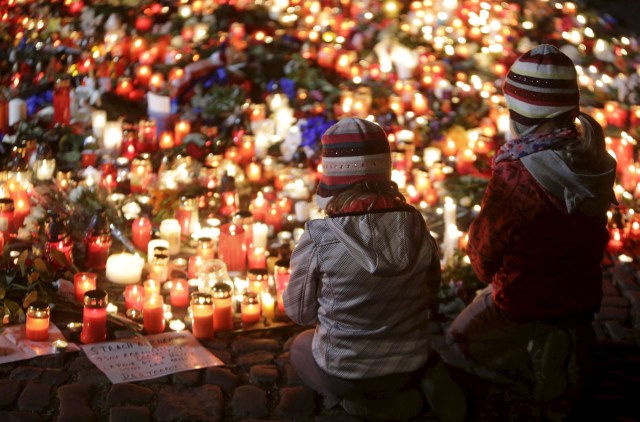 Children pray for the victims of the Paris attacks in front of the French embassy in Prague, Czech Republic, November 14, 2015. REUTERS/David W Cerny