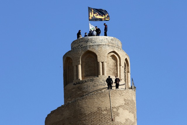 La gente visita la espiral minarete de la Gran Mezquita de Samarra, 3 de febrero de 2016. Las palabras en la bandera leen, "Imam Hussein". Fotografía tomada 3 de febrero de 2016. REUTERS / Ahmed Saad