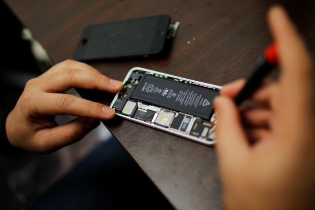 Un trabajador intenta reparar un iPhone en una tienda en Nueva York. Reuters