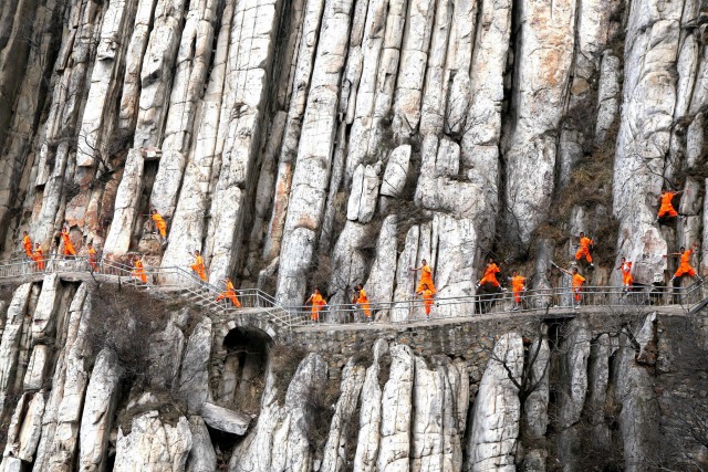 Los estudiantes de una escuela de artes marciales de Shaolin Kung Fu practican en los acantilados en Dengfeng, provincia de Henan, China, 17 de marzo de 2016. REUTERS / Stringer,