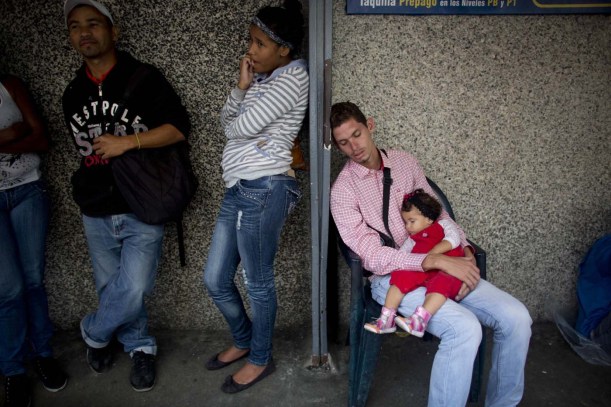 En esta imagen, tomada el 3 de mayo de 2016, un grupo de personas espera en una fila en el exterior de un supermercado para comprar comida, en Caracas, Venezuela. Los precios andan por las nubes gracias a la escasez, el acaparamiento y los revendedores del mercado negro. Los venezolanos hacen fila una y otra vez para adquirir bienes subsidiados, sin saber qué habrá cuando finalmente les toque el turno. (AP Foto/Ariana Cubillos)