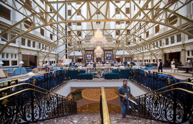 Workers move around inside the Trump International Hotel during it's 'soft-opening' in downtown Washington, Monday, Sept. 12, 2016 in Washington. The luxury hotel Donald Trump has built in an iconic downtown Washington building is set to open. The Trump International Hotel will begin serving guests Monday. There won't be any fanfare around the opening, which is known as a "soft opening." Grand-opening ceremonies are being planned for October. The Trump Organization won a 60-year lease from the federal government to transform the Old Post Office building on Pennsylvania Avenue into a hotel. (AP Photo/Pablo Martinez Monsivais)