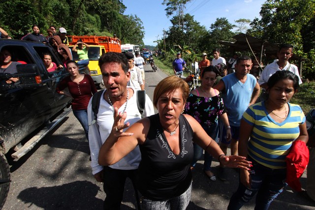 People protest on the "Troncal 5" road over the lack of cash as the new bank notes have not appeared, in San Cristobal, in Venzuela's Tachira state, on December 16, 2016.  Venezuelans lined up to deposit 100-unit banknotes before they turned worthless, but replacement bills had yet to arrive, increasing the cash chaos in the country with the world's highest inflation. Venezuelans are stuck in currency limbo after President Nicolas Maduro ordered the 100-bolivar note -- the largest denomination, currently worth about three US cents -- removed from circulation in 72 hours. / AFP PHOTO / GEORGE CASTELLANOS