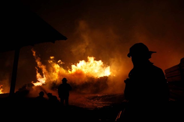 Bomberos trabajando en un incendio forestal en Santa Olga, Chile, ene 27, 2017. Chile cuenta con los mecanismos de financiamiento necesarios para atender la emergencia generada por los voraces incendios forestales que afectan la zona centro-sur del país, dijo el viernes el ministro de Hacienda, Rodrigo Valdés.  REUTERS/Rodrigo Garrido