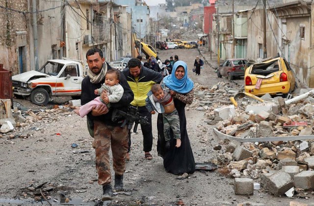 Un soldado de las fuerzas especiales iraquíes ayuda a una familia a desplazar a su hijo desde la parte de Mosul en manos del Estado Islámico hacia la controlada por las fuerzas iraquíes.