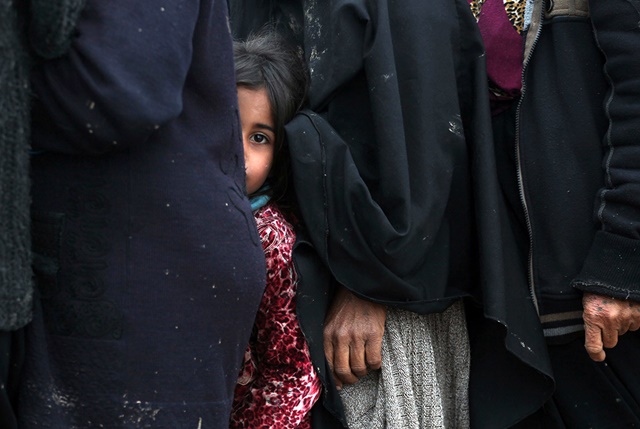 Iraquíes desplazados hacen cola para recibir ayuda en el campo de Hammam al-Alil, al sur de Mosul