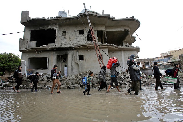 Los habitantes del barrio Bab al-Tob del centro de Mosul huyen de sus casas